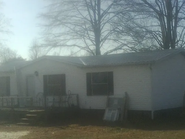 New metal roof on a white painted brick home on a foggy morning in Pennock