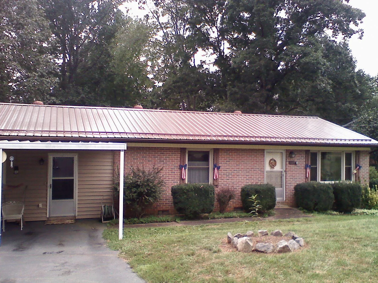 Bronze metal roof and carport on a brick ranch home — Roof Repair work by our crew in Pennock