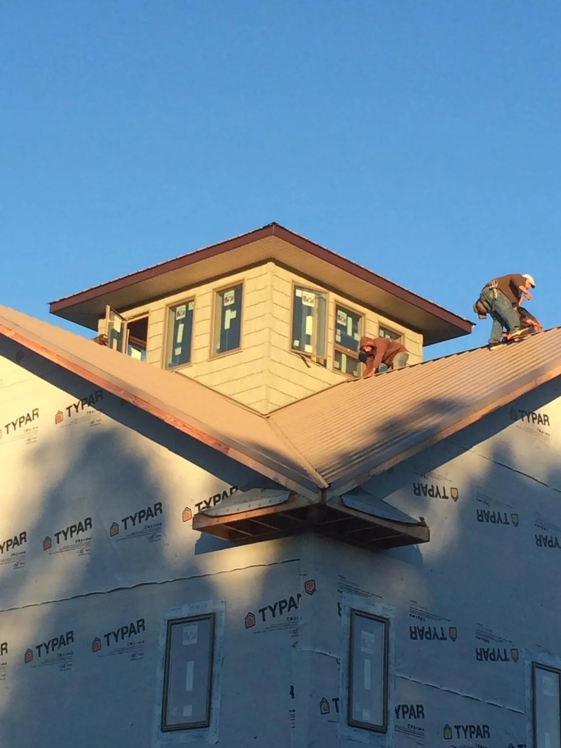 Roofers working around a rooftop cupola on a new metal roof at sunset — Roof Waterproofing in Pennock by Roofing Brothers